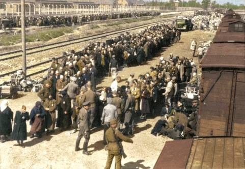  Irene (zweite Frau von Links mit einem Kopftuch) sucht während der Selektion auf der Rampe nach ihrer Schwester.
